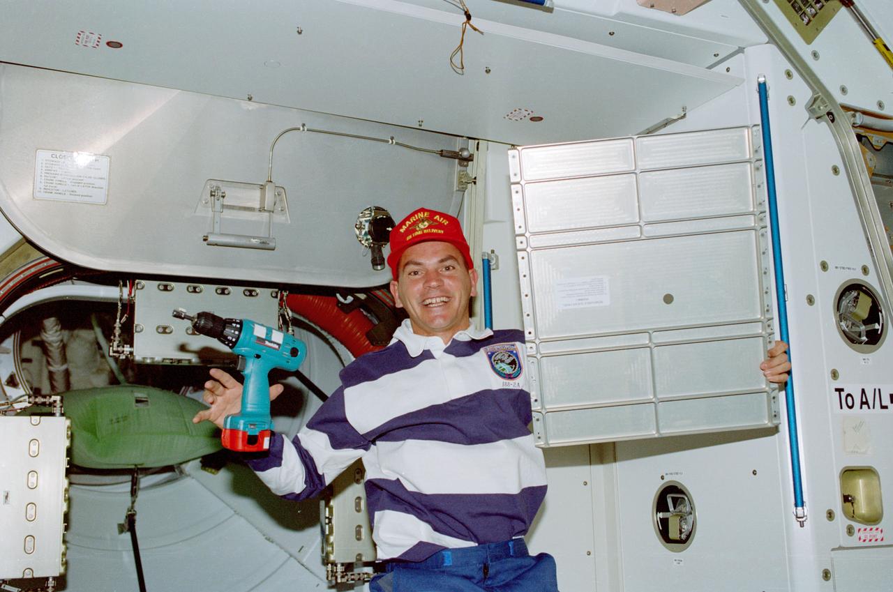 STS088-359-003 (4-15 Dec. 1998) --- Astronaut Frederick W. ?Rick? Sturckow, pilot, holds up a panel while putting final touches on the interior of Node 1 or Unity.  Sturckow, who had been working with a battery-powered tool, was joined by other crew members in preparing the module for its International Space Station (ISS) duty.