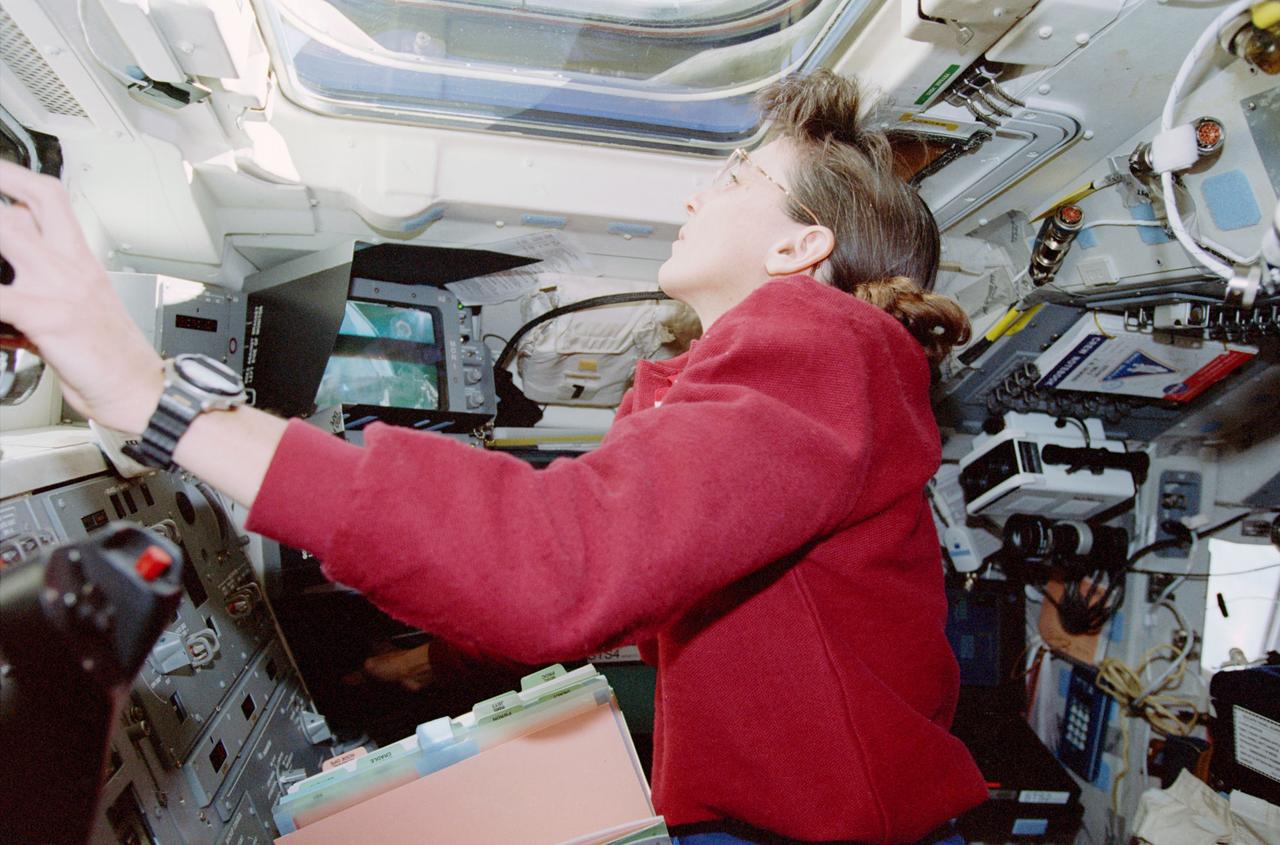 STS088-363-012 (4-15 Dec. 1998) --- Astronaut Nancy J. Currie, mission specialist, looks out the aft flight deck window while operating the Space Shuttle Endeavour?s Remote Manipulator System (RMS). The robot arm was being used to assist Endeavour?s two space walking astronauts -- Jerry L. Ross and James H. Newman, mission specialists.