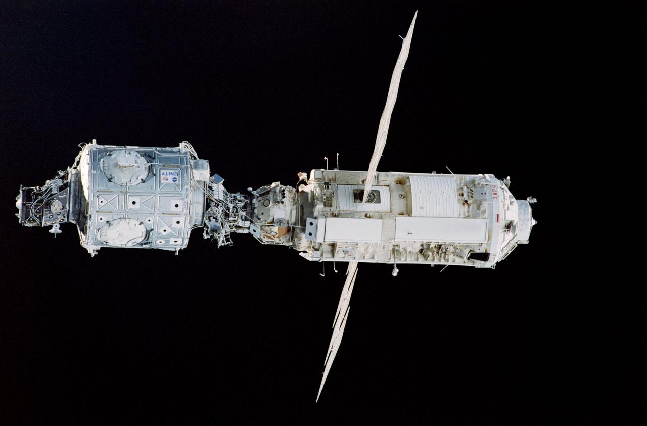 STS088-365-004 (4-15 Dec. 1998) --- The U.S.-built Unity Connecting Module and the Russian-built FGB (Zarya, with solar panels deployed) are backdropped against the blackness of space in this 35mm photograph taken from the Space Shuttle Endeavour.  After devoting the major portion of its mission time to various tasks to ready the two docked modules for their International Space Station (ISS) roles, the six-member crew released the tandem and performed a fly-around survey of the hardware.