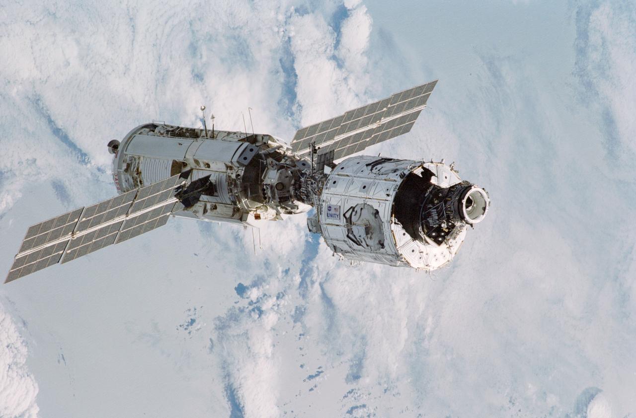 STS088-365-020 (4-15 Dec. 1998) --- A variety of white and gray clouds form the backdrop for this  35mm scene of the connected Zarya and Unity modules floating in space after having been released from Endeavour's cargo bay a bit earlier.  Six crew members, who had earlier spent the majority of their on-duty mission time working on the tandem of space hardware, watched from Endeavour as the joined modules moved away from the shuttle.