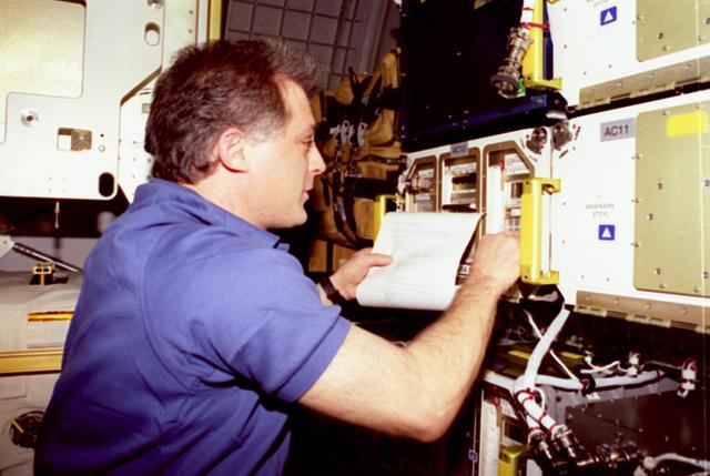 STS089-301-037 (22-31 Jan. 1998) --- Astronaut David A. Wolf, recently transferred to the STS-89 crew as mission specialist, works with samples in the Commercial Generic Bioprocessing Assembly (CGBA) onboard the Earth-orbiting space shuttle Endeavour.  Wolf had earlier completed a four-month tour of duty on the Russian Space Agency's (RSA) Mir Space Station, as a cosmonaut guest researcher. Photo credit: NASA