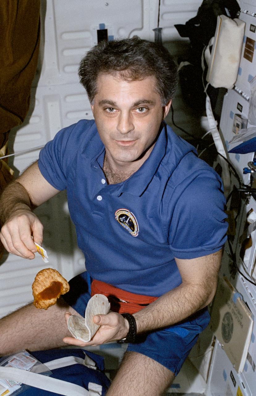 STS089-370-034 (22-31 Jan. 1998) --- Astronaut David A. Wolf, freshly removed from a long stay aboard Russia’s Mir Space Station, creates a sandwich onboard the Earth-orbiting space shuttle Endeavour.  Wolf had earlier been replaced on Mir by Andrew S. W. Thomas, cosmonaut guest researcher, who will be last NASA astronaut assigned to Mir duty as part of the Phase I program. Photo credit: NASA