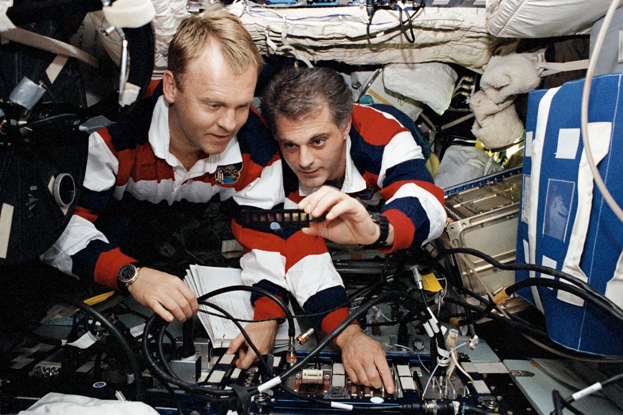 STS089-390-008 (22-31 Jan 1998) --- Astronauts David A. Wolf (right), newly a member of the Space Shuttle Endeavour STS-89 crew; and Andrew S. W. Thomas, his cosmonaut guest researcher replacement on the Russia?s Mir Space Station, Mir-24 crew, check out the CoCult hardware, a Mir tissue experiment.  Wolf is holding a sample display from the hardware.