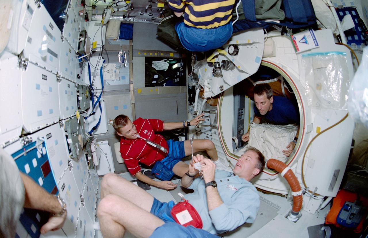 STS090-351-009 (17 April - 3 May 1998) --- Three members of the Neurolab crew were photographed during off-duty time on the mid-deck aboard the Earth-orbiting Space Shuttle Columbia.  Left to right are James A. (Jim) Pawelczyk, payload specialist, and astronauts Richard A. Searfoss, mission commander; and Richard M. Linnehan, payload commander.  Linnehan is in the hatchway of the tunnel that connected the crew members to the Spacelab Science Module in Columbia's cargo bay.  A &quot;fish-eye&quot; lens on a 35mm camera gives the scene a slightly distorted look.  Five NASA astronauts and two payload specialists went on to spend a little more than 16-days in Earth-orbit in support of the Neurolab mission.