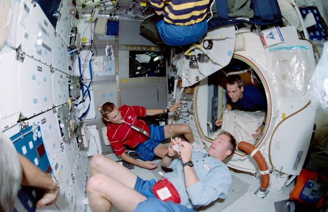 NASA image: Fish-eye view of Williams, Searfoss and Pawelczyk on middeck during meal