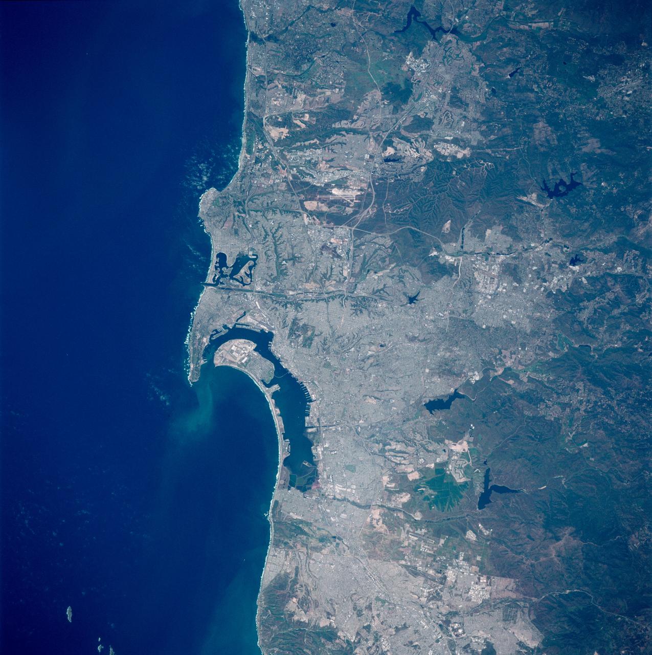 STS090-758-018 (17 April - 3 May 1998) --- The Space Shuttle Columbia was almost directly over the San Diego, California, area when this scene was captured with a 70mm handheld camera.  In order for north to appear toward the top of the frame, it should be held with the Pacific Ocean waters to the left.  The United States Naval Air Station, the United States Naval Training Center, United States Marine Corps (USMC) Recruit Depot and the United States Naval Station are all visible just left of center on or near the island and peninsula features.  Among the many bodies of water visible in the photo are Mission Bay, San Diego Bay, Lower Otay Reservoir, Sweetwater Reservoir and El Capitan Reservoir.