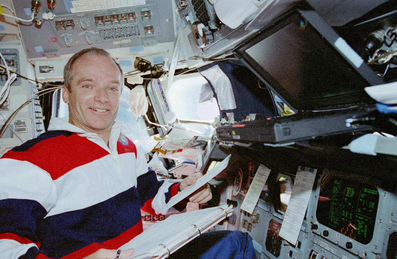 STS091-360-014 (2-12 June 1998) --- Astronaut Charles J. Precourt mans the commander's station on the flight deck of the Space Shuttle Discovery during NASA's  scheduled final rendezvous operations with Russia's Mir space station. The veteran astronaut holds checklists related to the rendezvous activities.