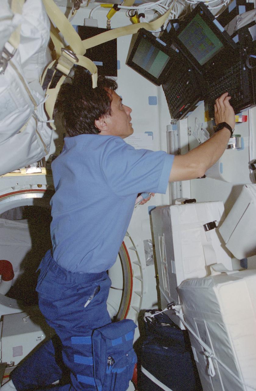STS091-378-028 (2-12 June 1998) --- Astronaut Franklin R. Chang-Diaz, payload commander, inputs data on a laptop computer associated with the Alpha Magnetic Spectrometer (AMS) hardware located in the aft cargo bay. Reference JSC photo number STS091-367-033, which shows the hardware as seen from Russia's Mir space station, which was docked with Discovery at the time. AMS is the first large magnet experiment ever placed in Earth orbit. The scientific goal of this high-energy physics experiment is to increase our understanding of the composition and origin of the universe. It is designed to search for and measure charged particles, including antimatter, outside Earth's atmosphere. The charge of such particles can be identified by their trajectories in a magnetic field.