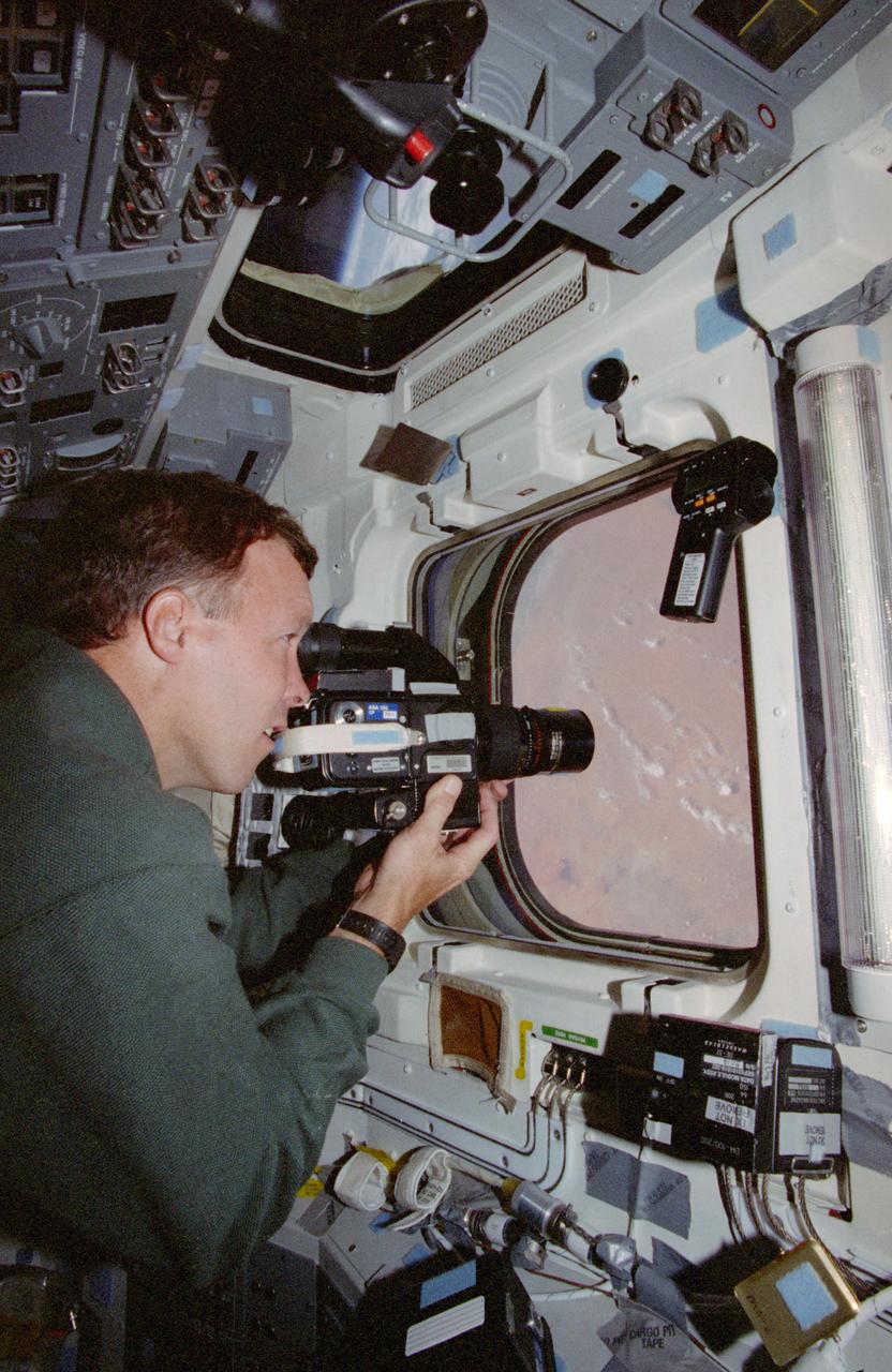 STS091-391-033 (2-12 June 1998) --- On Discovery's aft flight deck, astronaut Dominic C. Gorie, pilot, uses a 70mm handheld camera to record images of Africa.  Two overhead and two head-level windows, located on the aft flight deck, afford an easy means for astronauts-turned-photographers to take pictures of targets of opportunity on the home planet.