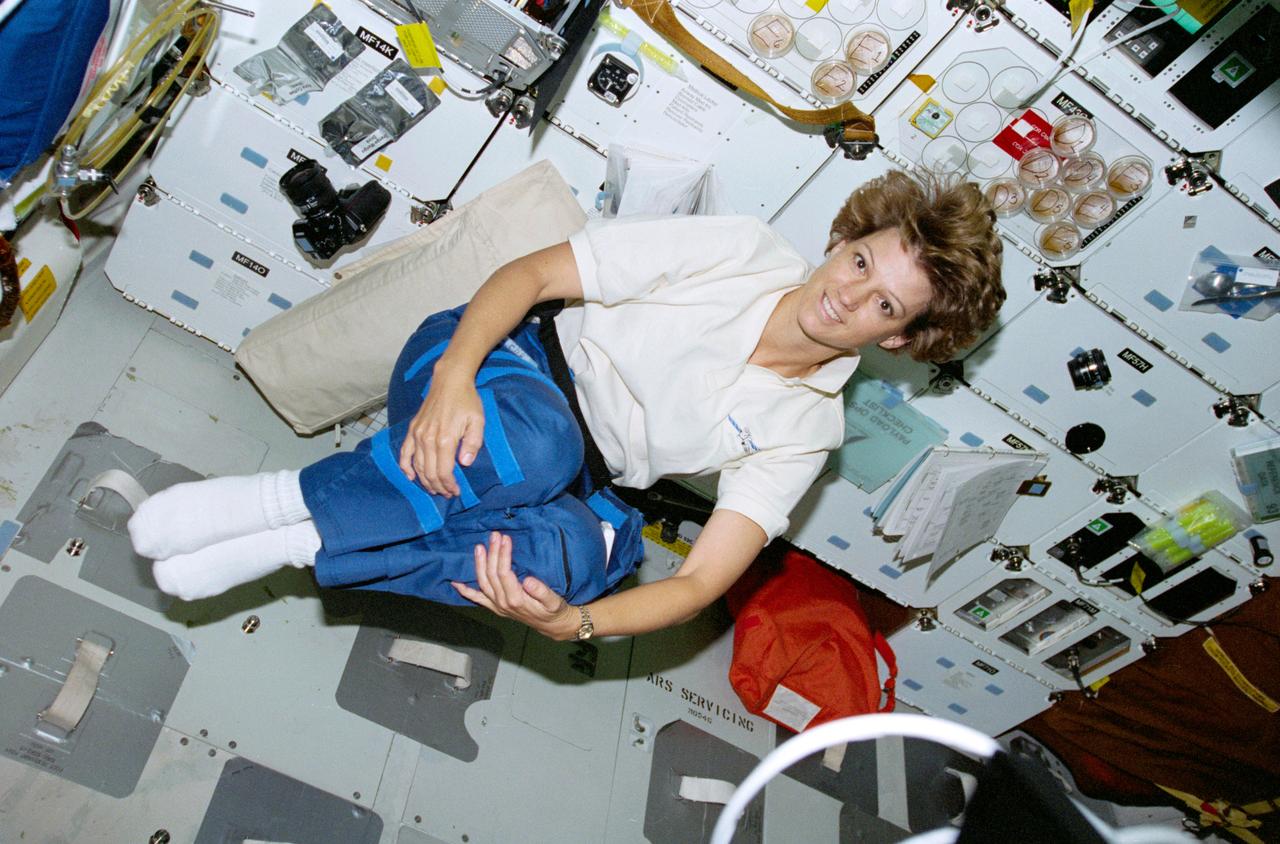 STS093-321-017 (23-27 July 1999) ---  Astronaut Eileen M. Collins, mission commander, floats on Columbia's middeck  during a free moment.  She and four  other astronauts spent almost five days in Earth orbit in support of the STS-93 mission.  The first day was perhaps the astronauts' busiest, as it was on that day they deployed the world's most powerful X-Ray telescope and began to conduct a battery of in-cabin experiments.