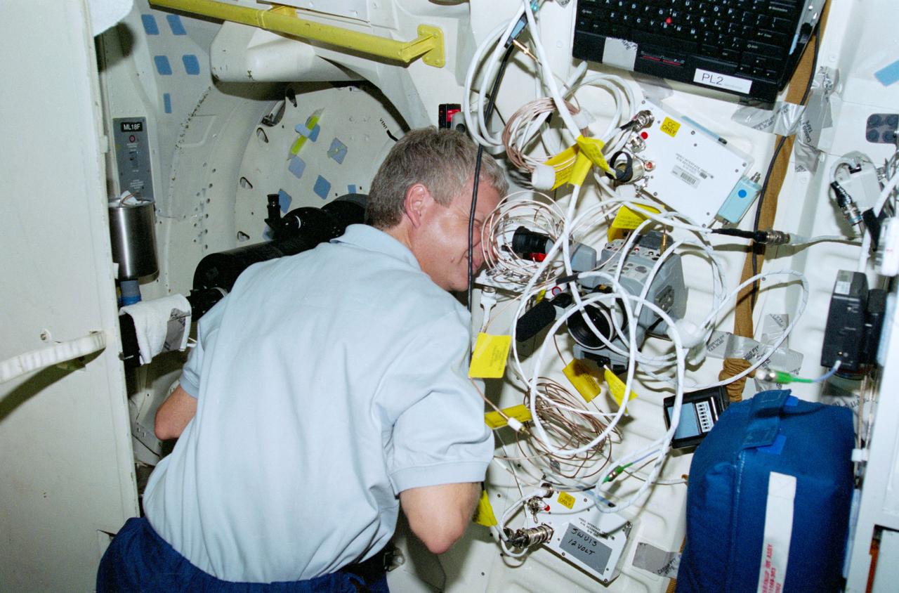 STS093-321-018 (22-27 July 1999) --- Astronaut Steven A. Hawley, mission specialist, works with the Southwest Ultraviolet Imaging System (SWUIS) experiment on the mid deck of the Space Shuttle Columbia.