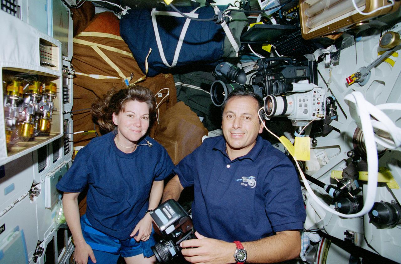 STS093-321-035 (23-27 July 1999) ---  Astronauts Catherine G. (Cady) Coleman and Michel Tognini, mission specialists,  check out the Lightweight Flexible Solar  Array Hinge (LFSAH, upper left) on Columbia's middeck.  LFSAH consists of  several hinges fabricated from shape-memory alloys and other spacecraft appendages.  During the five-day STS-93 flight, the experiment demonstrated the deployment capability of a number of hinge configurations. The experiment is sponsored by the U.S. Air Force Research Lab, Kirtland Air Force Base.  Tognini  represents the Centre National d'Etudes Spatiales (CNES) of France.