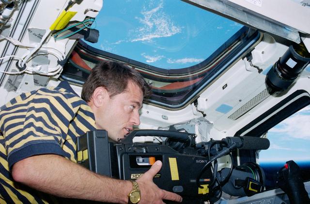 NASA image: STS-93 Pilot Ashby takes video footage from the flight deck of Columbia