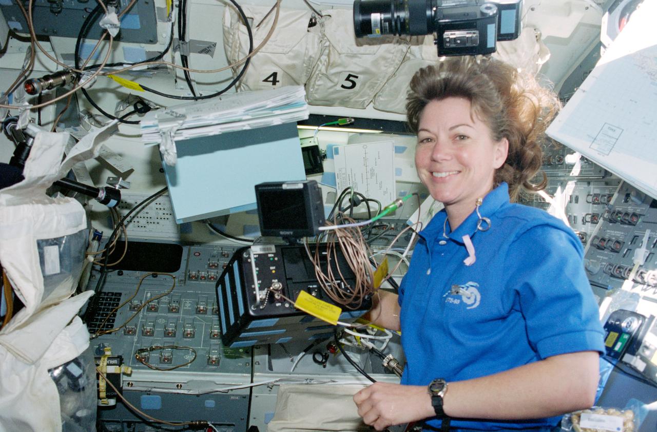 STS093-346-029 (22-27 July 1999) --- Astronaut Catherine G. Coleman, mission specialist, sets up the Heads Up Display (HUD) camera on the flight deck of the Earth-orbiting Space Shuttle Columbia.
