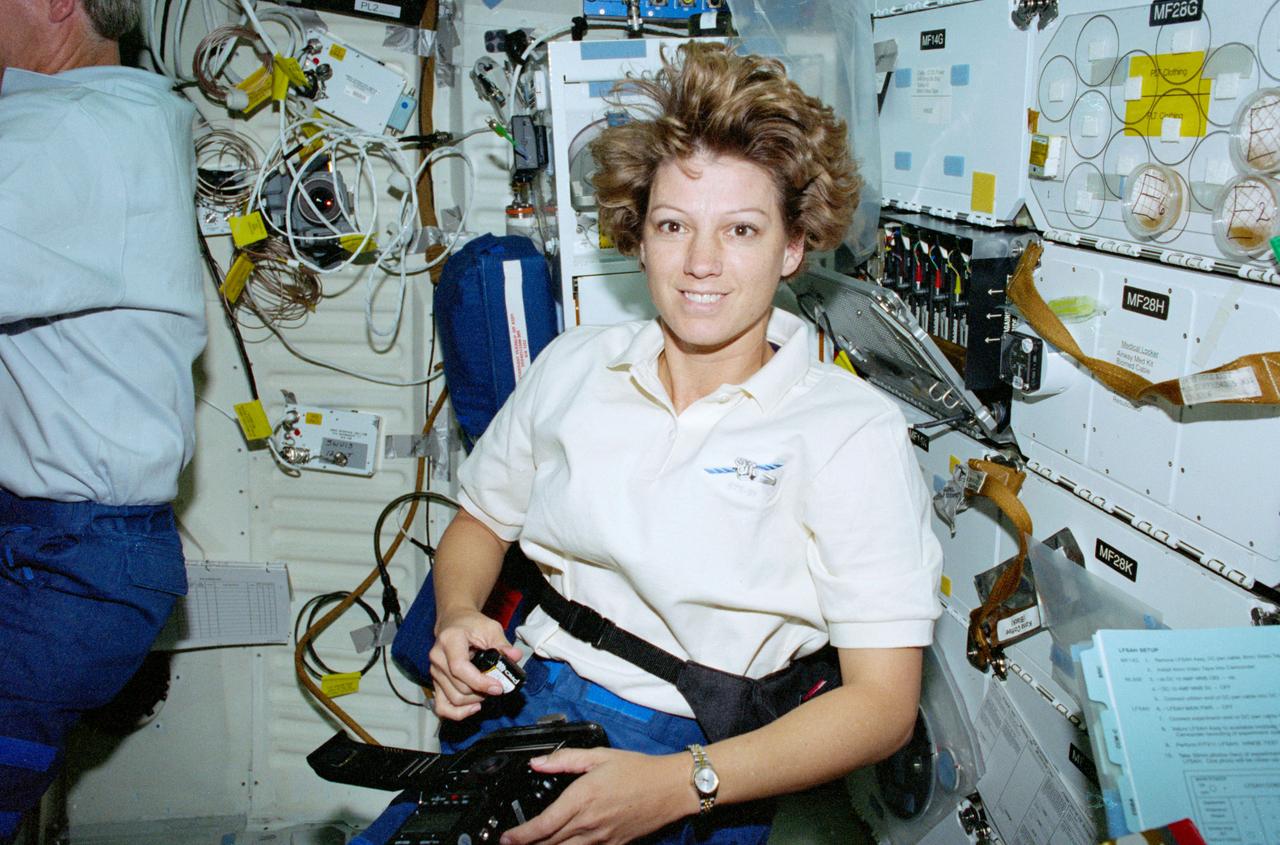 STS093-347-015 (23-27 July 1999) ---  Astronaut Eileen M. Collins, mission commander, loads a roll of film into a still camera on Columbia's middeck.   Collins is the first woman mission commander in the history of human space flight.