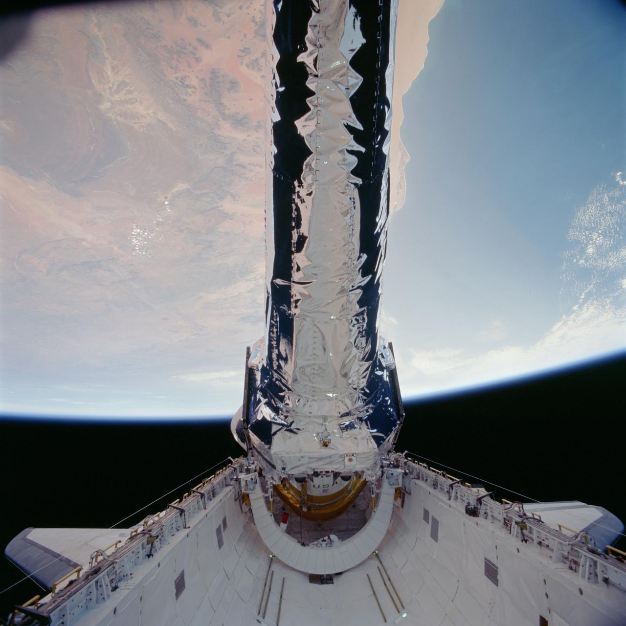 STS093-702-041 (23 July 1999)--- This 70mm frame shows the Chandra X-Ray observatory, backdropped against a desert area in Namibia, just before its release from Columbia's payload bay. The  primary duty of the STS-93 crew was to deploy the world's most powerful X-Ray telescope. It was also one of the first actions of the astronauts, occurring just a few hours following the shuttle's arrival in Earth orbit. This scene is one of a series of still photos recorded by the crew before and during the deployment of the 50,162 pound observatory.