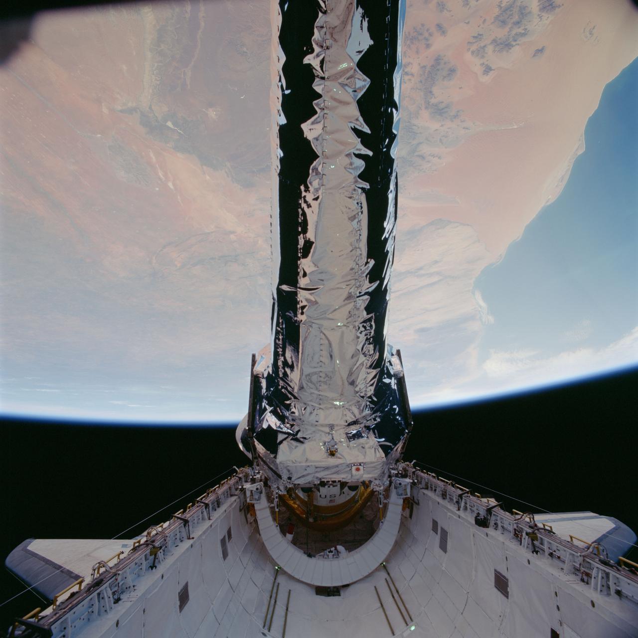STS093-702-048 (23 July 1999)--- This 70mm frame shows the Chandra X-Ray observatory, backdropped against a desert area in Namibia, just before its release from Columbia's payload bay. The primary duty of the STS-93 crew was to deploy the world's most powerful X-Ray telescope. It was also one of the first actions of the astronauts,  occurring just a few hours following the shuttle's arrival in Earth orbit. This scene is one of a series of still photos recorded by the crew before and during the deployment of the 50,162 pound observatory.