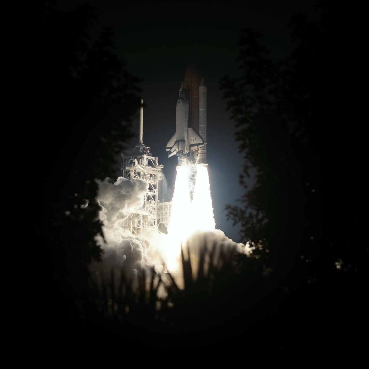 STS93-S-007 (23 July 1999) --- Framed by Florida foliage in this night time scene, the Space Shuttle Columbia lifts off from Launch Pad 39B to begin the five-day STS-93 mission. After two unsuccessful attempts earlier in the week, liftoff occurred at 12:31 a.m. (EDT), July 23, 1999. Only hours after this picture was taken, the five-member crew released the Chandra X-Ray Observatory into orbit. Onboard were astronauts Eileen M. Collins, first woman shuttle commander; Jeffrey S. Ashby, pilot; and Steven A. Hawley, Catherine G. Coleman and Michel Tognini, all mission specialists. Tognini represents the Centre National d'Etudes Spatiales (CNES) of France.