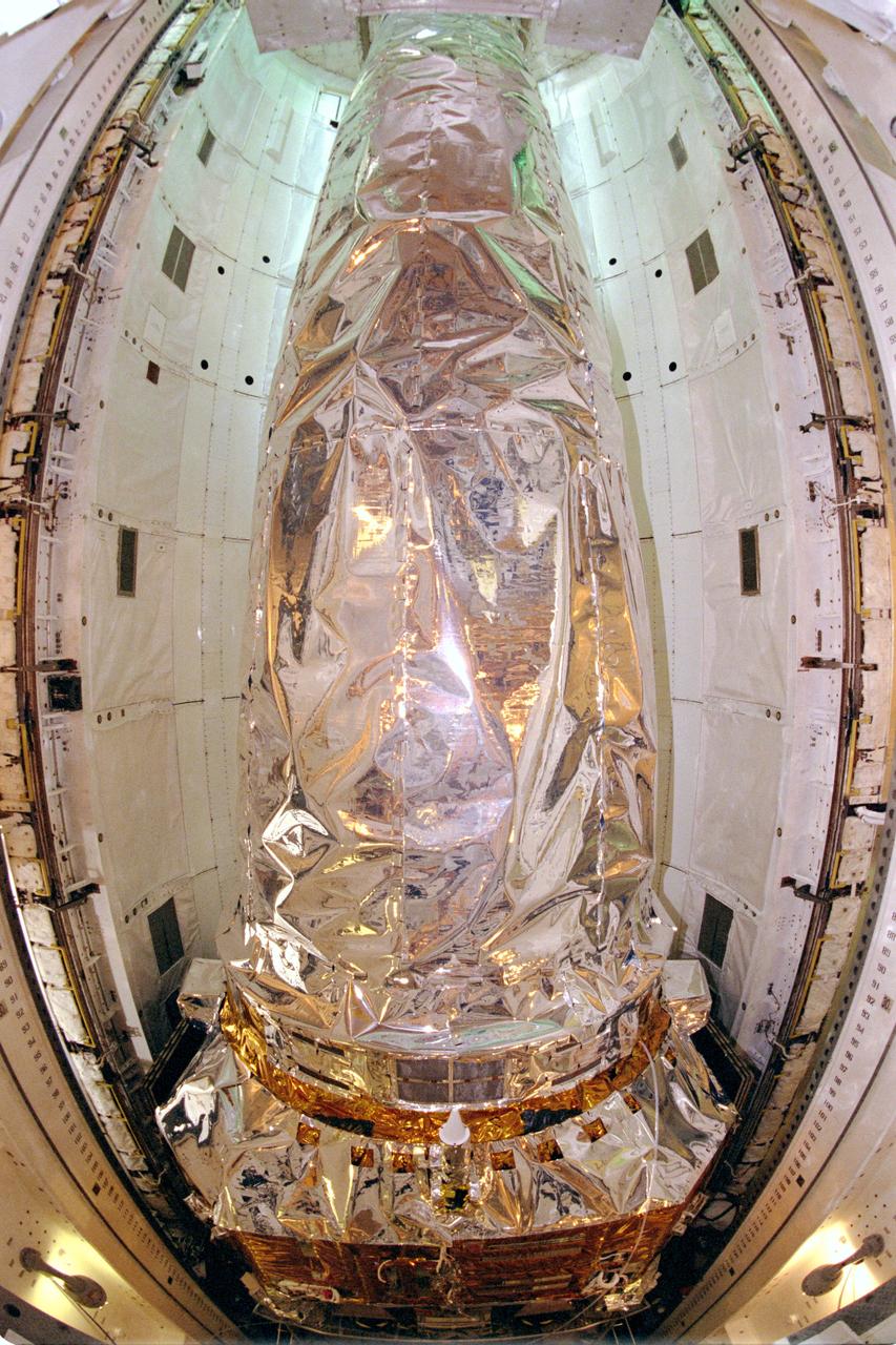 STS093-S-013 (27 June 1999) --- In this fish-eye view, the Chandra X-ray Observatory rests inside the payload bay of the Space Shuttle Columbia at the Kennedy Space Center (KSC).  Chandra is the primary payload on the STS-93 mission, scheduled to launch next month.  The world's most powerful X-ray telescope, Chandra, will allow scientists from around the world to see previously invisible black holes and high-temperature gas clouds, giving the observatory the potential to rewrite the books on the structure and evolution of the universe.