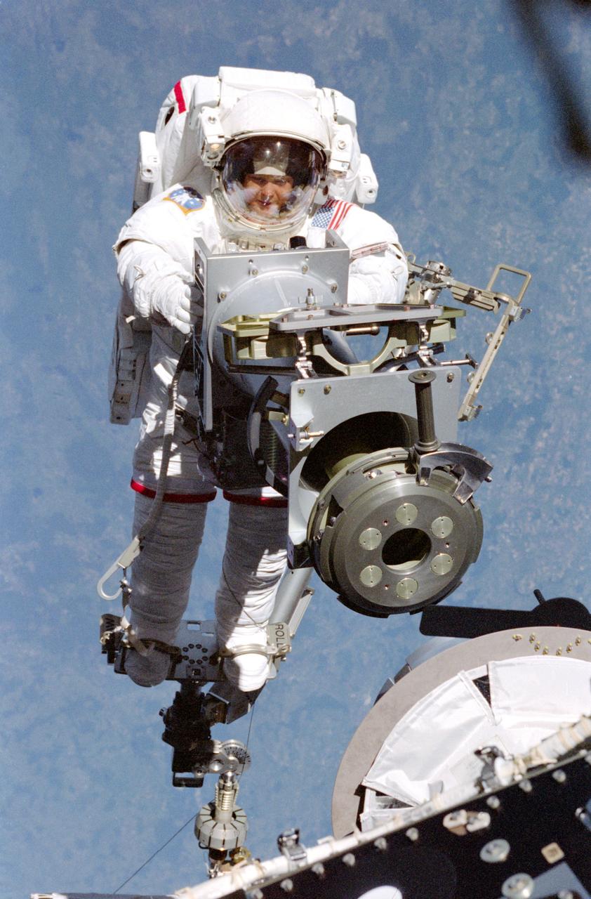 STS096-357-003 (30 May 1999) --- Astronaut Tamara E. Jernigan, backdropped against terrain some 173 nautical miles beneath Discovery, totes part of a Russian-built crane, called Strela (a Russian word meaning &quot;arrow&quot;). Jernigan's feet are anchored on a mobile foot restraint connected to the shuttle's remote manipulator system (RMS).  Astronauts Jernigan and Daniel T. Barry eventually spent over seven hours on the space walk.