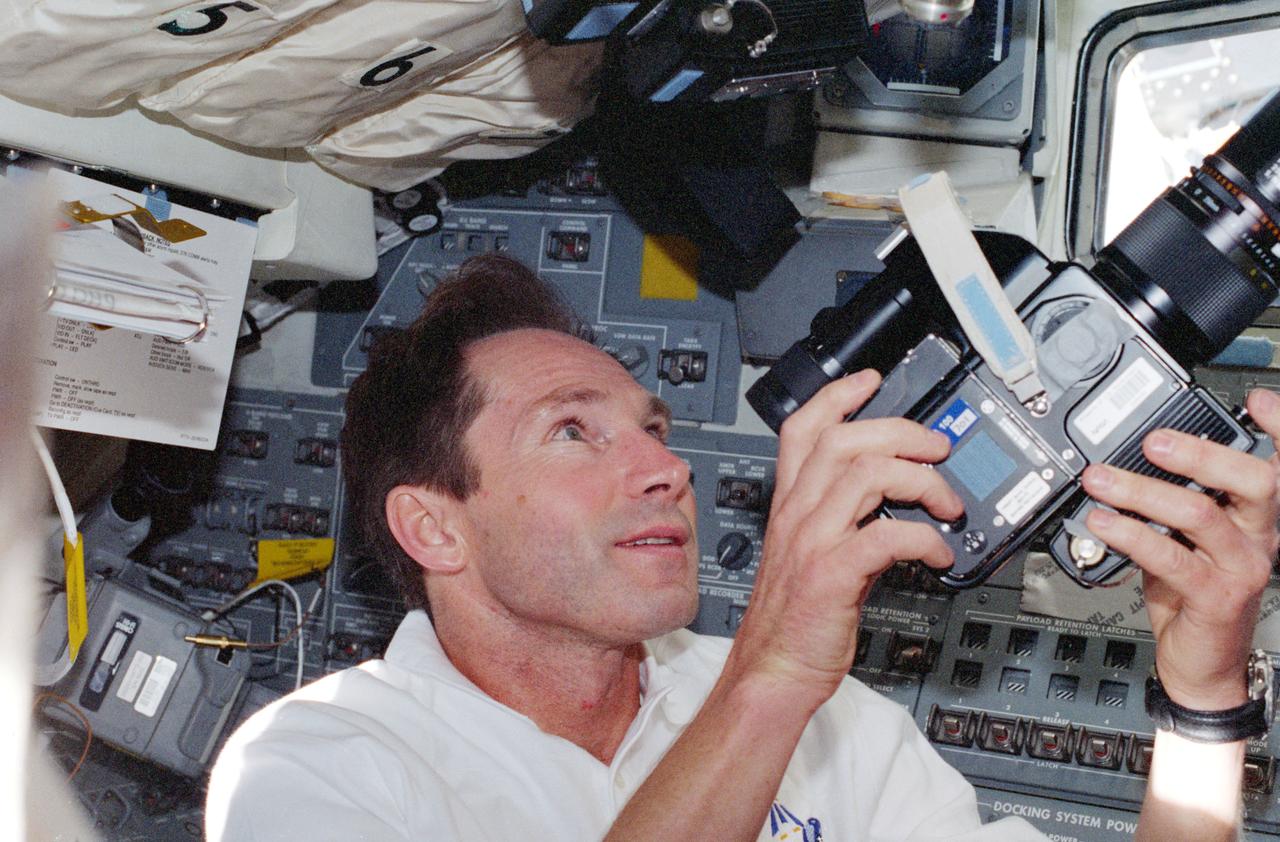 STS096-360-017 (27 May - 6 June 1999) --- Cosmonaut Valery I. Tokarev, mission specialist, prepares to use a handheld 70mm camera to record out-the-window activity from Discovery's aft flight deck. Tokarev represents the Russian Space Agency (RSA).