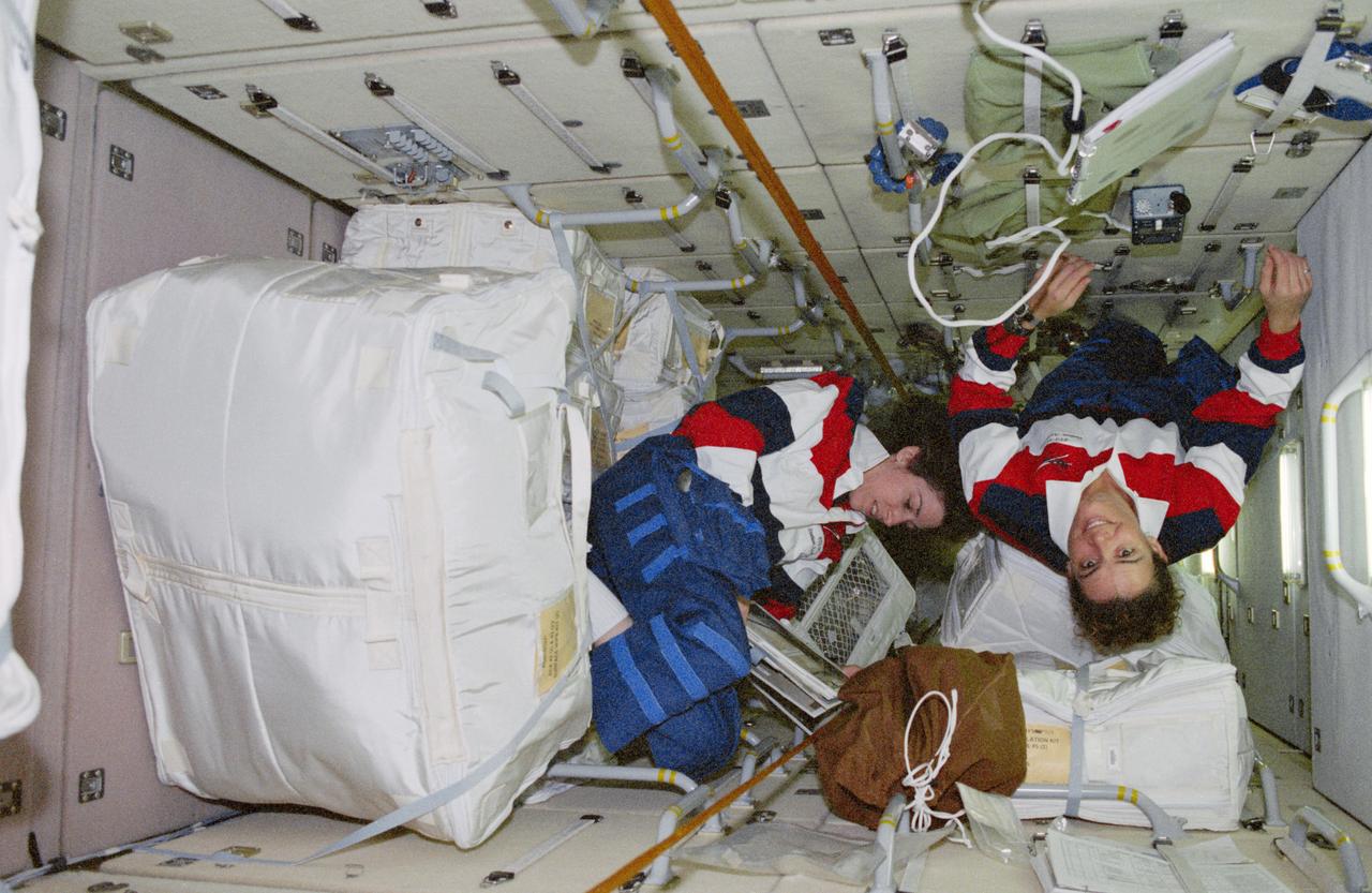 STS096-364-015 (27 May - 6 June 1999) --- Onboard the Russian-built Zarya module, astronauts Julie Payette (left) and Ellen Ochoa handle a portion of the supplies which have been moved over from the docked Discovery.  Payette represents the Canadian Space Agency (CSA).