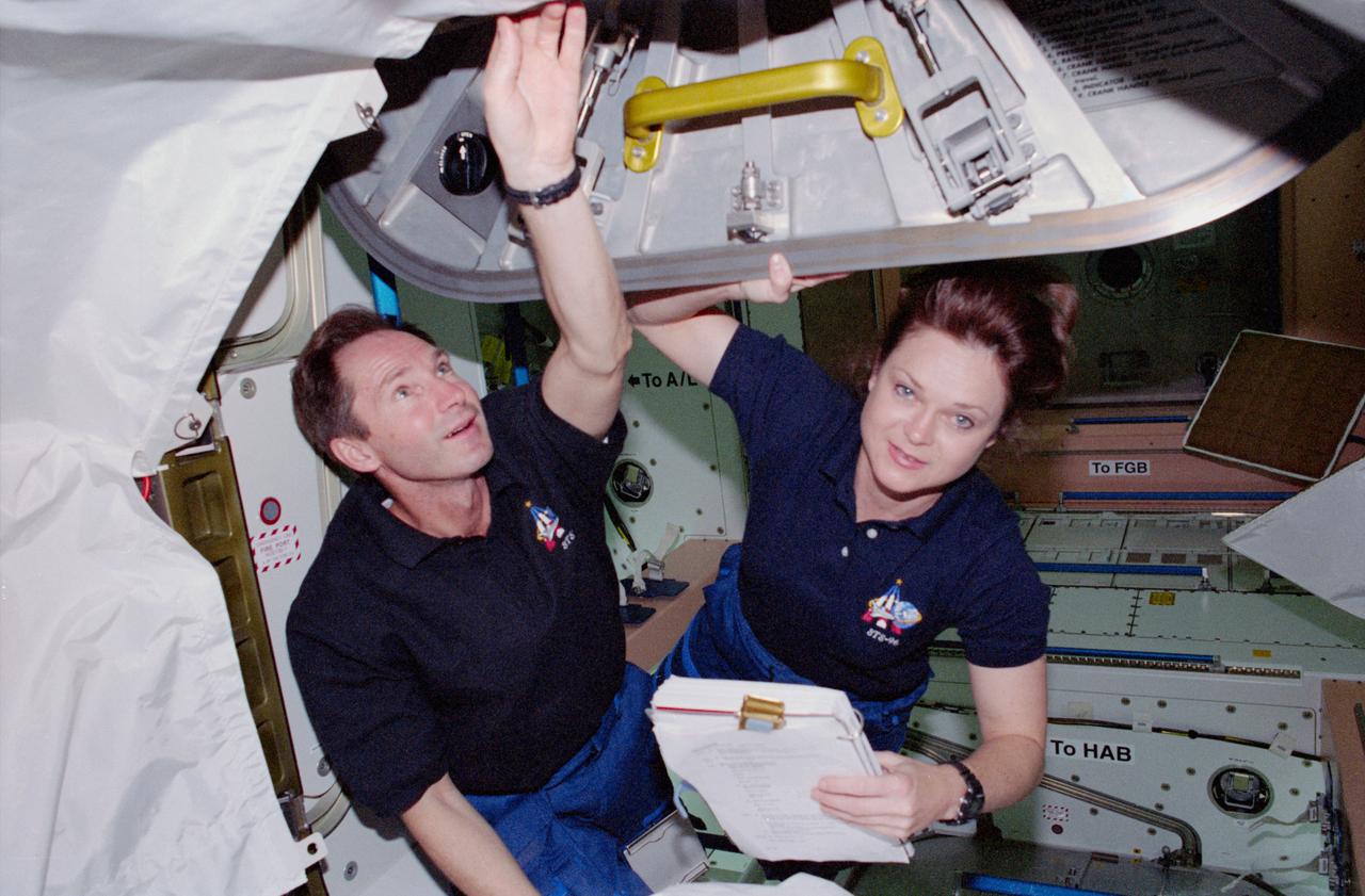 STS096-376-012 (30 May 1999) --- Cosmonaut Valery I. Tokarev and astronaut Tamara E. Jernigan, mission specialists, tote a checklist as they ingress the Unity node aboard the International Space Station (ISS) currently docked with the Space Shuttle Discovery in Earth orbit.  Tokarev represents the Russian Space Agency (RSA).