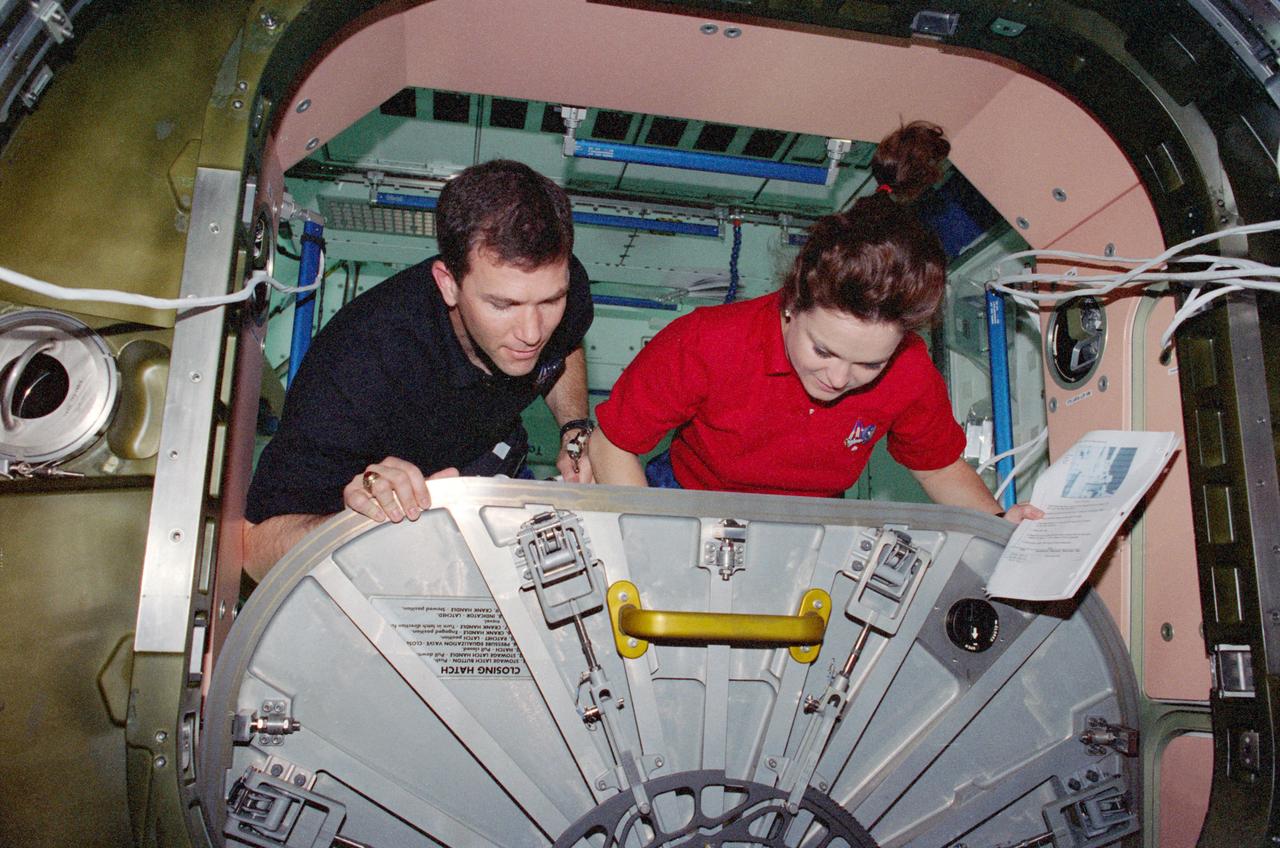 STS096-383-021 (27 May - 6 June 1999) -- Astronauts Rick D. Husband and Tamara E. Jernigan adjust the hatch for the U.S.-built Unity node. The task was part of the overall effort by the seven-member STS-96 crew to prepare the existing portion of the International Space Station (ISS).
