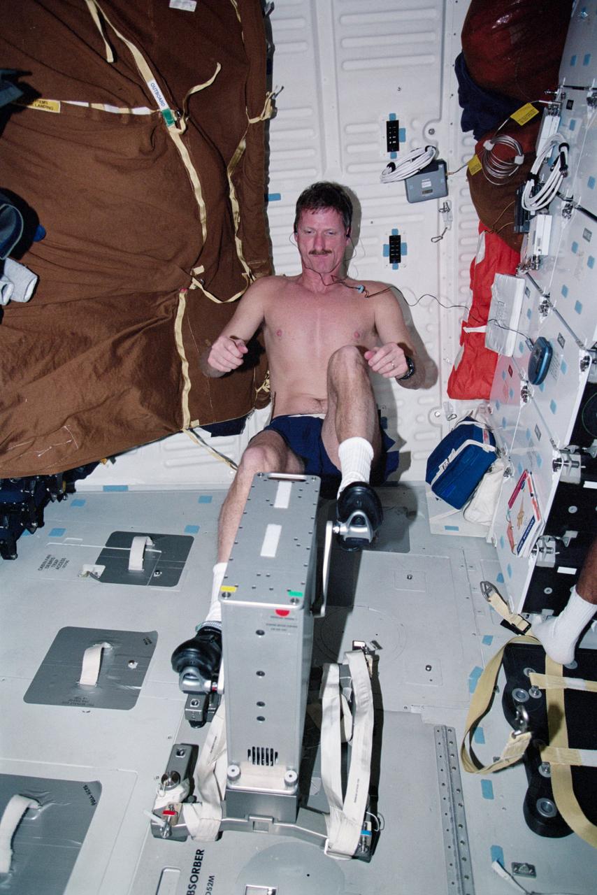 STS097-317-017 (30 Nov. - 11 Dec. 2000) Astronaut Joseph R. Tanner, STS-97 mission specialist, works out on the bicycle ergometer aboard the Space Shuttle Endeavour.