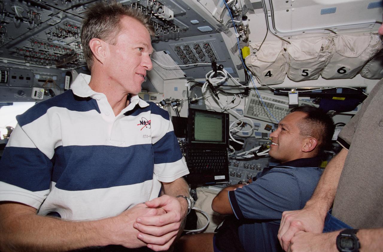 STS097-330-030 (30 Nov.-11 Dec. 2000) --- Astronauts Brent W. Jett (left), mission commander, and Carlos I. Noriega and Joseph R. Tanner (partially out of frame), both mission specialists, discuss mission procedures on the aft flight deck of the Space Shuttle Endeavour.