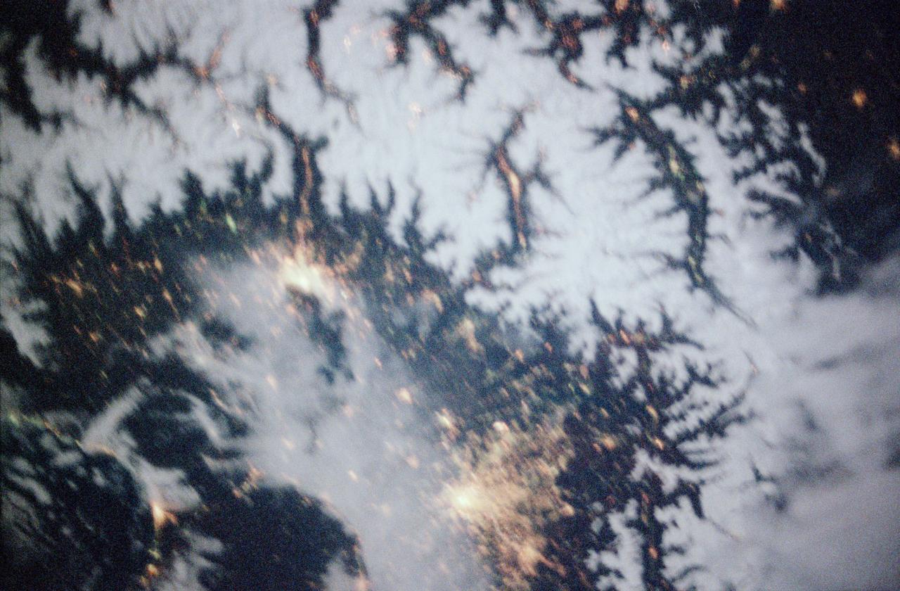 STS097-355-011 (30 Nov. -11 Dec. 2000) --- This vertical scene showing Torino and Milano, Italy, at night, was photographed with a 35mm camera by one of the STS-97 crew members aboard the Earth-orbiting Space Shuttle Endeavour. The night lights of Torino and Milano (two larger illuminated areas) are visible in the view, which covers the western end of the Po River Valley. Torino is the bright spot slightly left of center and Milano is the larger bright spot towards the bottom center of the image. The deeply eroded flanks of the snow-covered Alps Mountains (serrated-looking, light-colored terrain top half of the image) is visible north of the two large cities. Several mountain passes that connect the Po River Valley with France and Switzerland can be identified by the string of lights in the narrow, linear valleys. A translucent-looking cloud (bottom center) somewhat obscures the nighttime landscape south of Torino and Milano. The northwest coast of Italy, including the Italian city of Genova, can be identified in the lower left corner of the image. This photography was taken by astronauts using high speed film and long exposure on a night with a full moon illuminating the surface of the Earth.