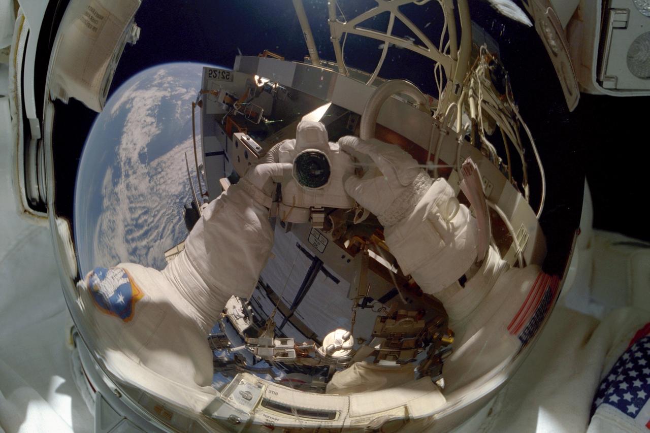 STS097-374-021 (3 December 2000) --- Astronaut Joseph P. Tanner, STS-97 mission specialist, used the pictured 35mm camera to expose a photo of his helmet visor during the flight's first space walk on Dec. 3, 2000. Among the objects visible among the reflections in the visor is part of the blue and white Earth, some 235 miles below.