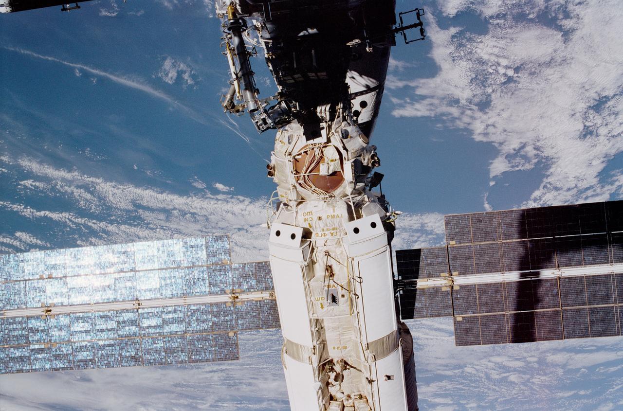 STS097-374-024 (3 December 2000) --- Backdropped by the Earth with partial cloud cover, the Functional Cargo Block (FGB) or Zarya is photographed with sunglint on the array. The photo was taken by astronaut Joseph R. Tanner during the first STS-97 space walk.