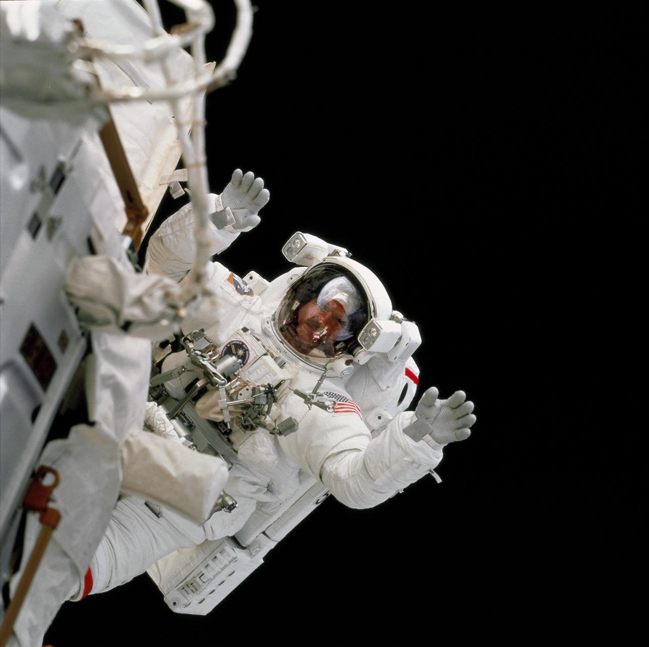 STS097-703-011 (7 December 2000) --- Astronaut Joseph R. Tanner waves to his cabin-bound crewmates during the December 7 extravehicular activity (EVA), one of three space walks involving him and astronaut Carlos I. Noriega. The photograph was taken by one of the non-EVA STS-97 crew members, using a 70mm camera.