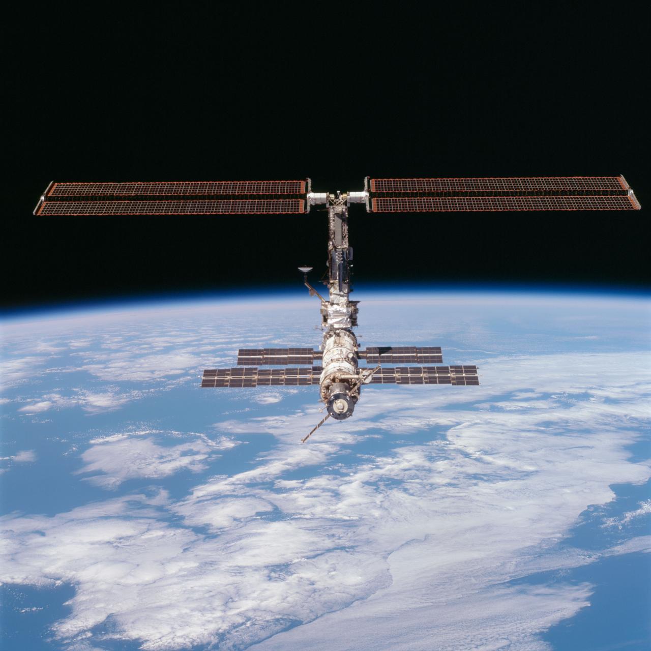 STS097-704-090 (9 December 2000) --- This picture of the distant International Space Station (ISS) blended against the darkness of space and the blue Earth at its horizon is one of a series of 70mm frames exposed of the station following undocking at 1:13 p.m. (CST), December 9, 2000. This series of images, as well as video and digital still imagery taken at the same time, represent the first imagery of the entire station with its new solar array panels deployed. Before separation, the shuttle and space station had been docked to one another for 6 days, 23 hours and 13 minutes. Endeavour moved downward from the space station, then began a tail-first circle at a distance of about 500 feet. The maneuver, with pilot Michael J. Bloomfield at the controls, took about an hour. While Endeavour flew that circle, the two spacecraft, moving at five miles a second, navigated about two-thirds of the way around the Earth. Undocking took place 235 statute miles above the border of Kazakhstan and China. When Endeavour made its final separation burn, the orbiter and the space station were near the northeastern coast of South America.