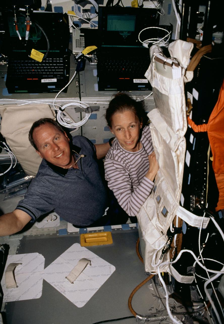 STS098-311-020 (7-20 February 2001) --- Astronauts Thomas D. Jones and Marsha S. Ivins, both mission specialists, are photographed on the mid deck of the Space Shuttle Atlantis near the Payload General Support Computers (PGSC).
