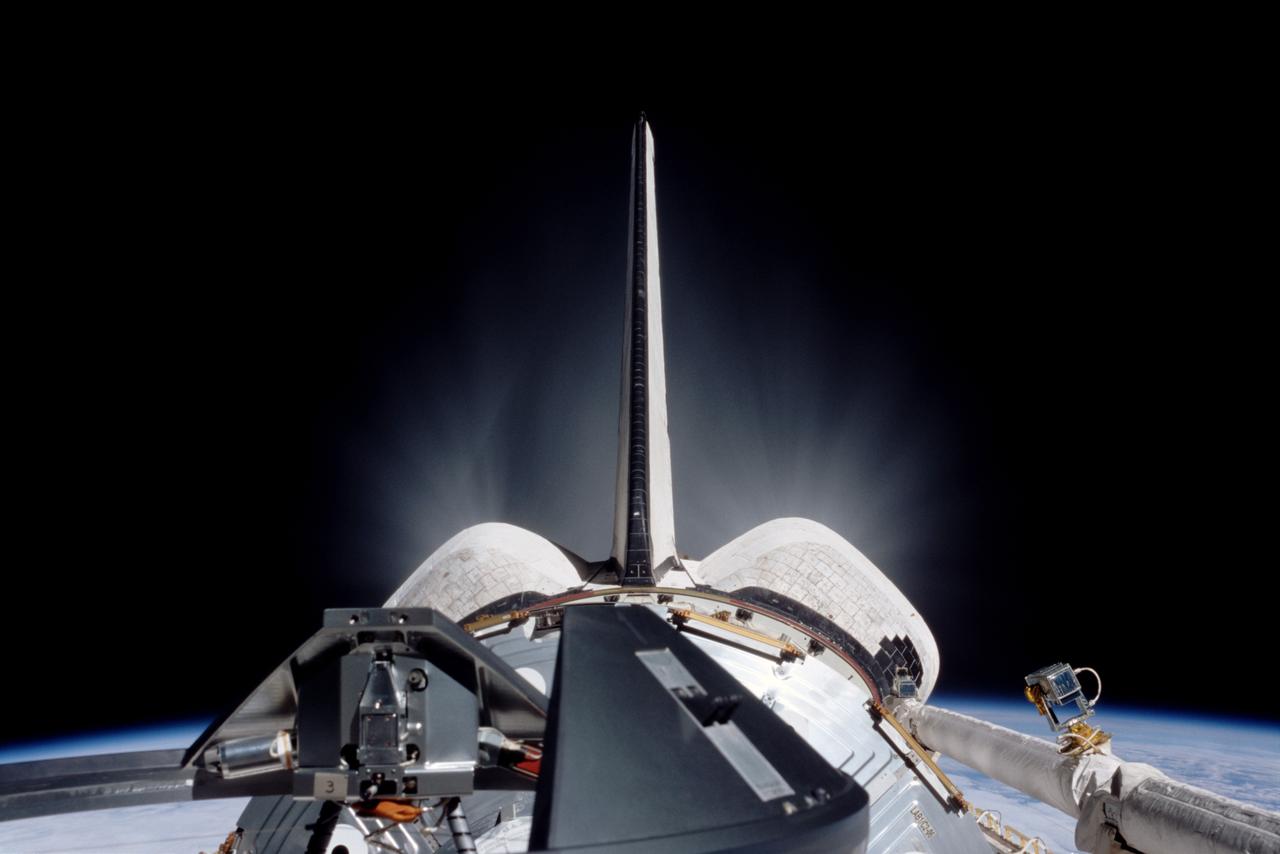STS098-324-0004 (7-20 February 2001) --- One of the astronauts on the aft flight deck of the Space Shuttle Atlantis used a 35mm camera to record this image of a thruster firing. Part of Earth's limb can be seen on either side of the orbital maneuvering system (OMS) pods below frame center.