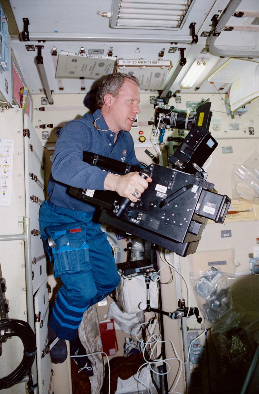 STS098-337-034 (7-20 February 2001) --- Astronaut Thomas D. Jones, mission specialist, is seen with an IMAX camera in the Zvezda service module of the International Space Station (ISS).