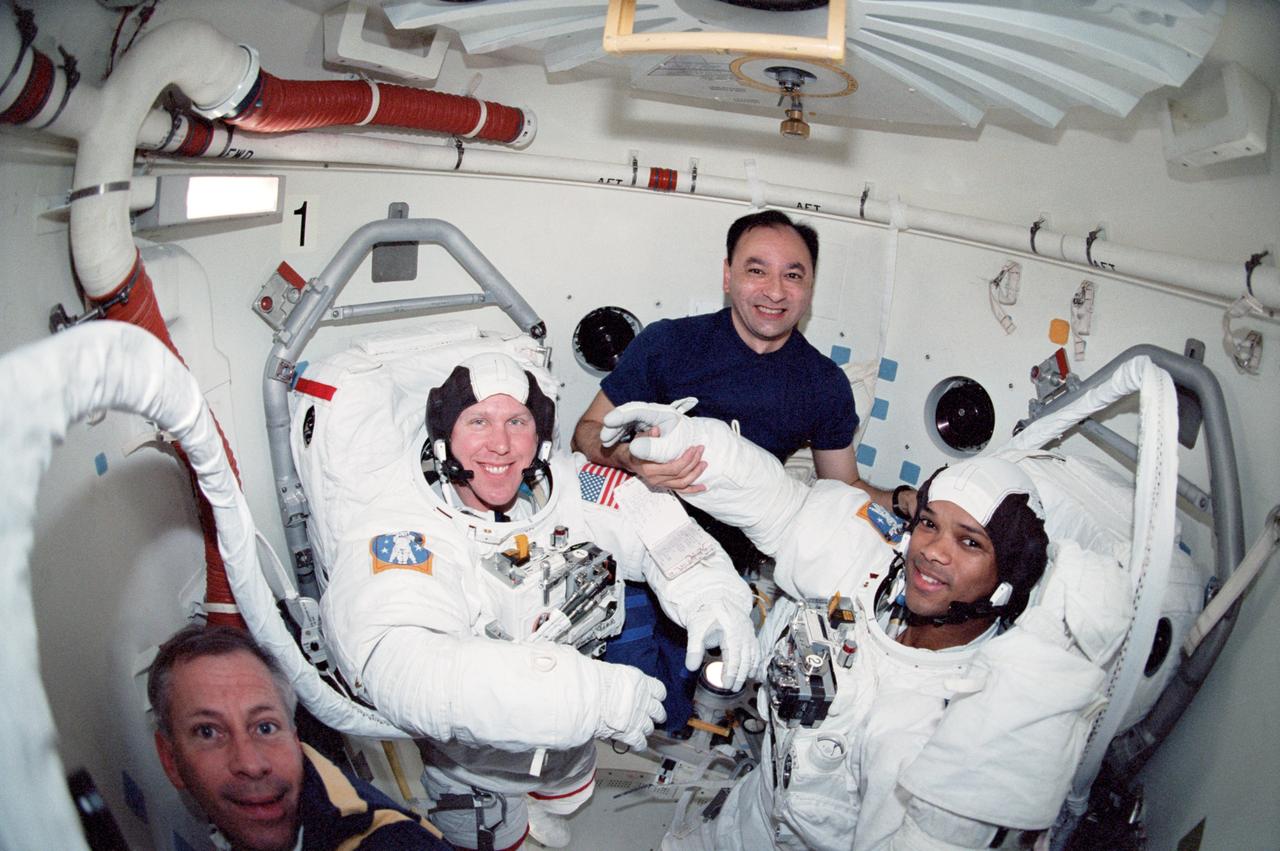 STS098-349-004 (7-20 February 2001) --- Astronauts Thomas D. Jones (second left) and Robert L. Curbeam, both mission specialists, prepare for one of the three STS-98 sessions of extravehicular activity (EVA). Astronauts Kenneth D. Cockrell (lower left), mission commander, and Mark L. Polansky, mission specialist, assist Jones and Curbeam as they don their Extravehicular Mobility Unit (EMU) space suits in the airlock of the Space Shuttle Atlantis.