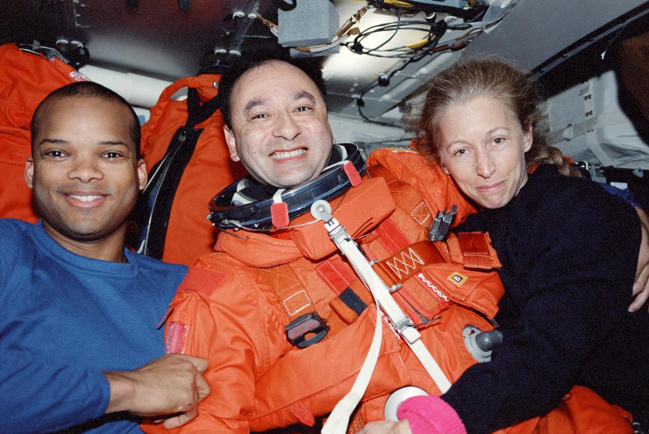 STS098-358-005 (7-20 February 2001) --- Astronauts Mark L. Polansky (center), pilot, Robert L. Curbeam, and Marsha S. Ivins, both mission specialists, paused for this photograph as they prepared to suit up in their full-pressure launch and entry suits on the mid deck of the Space Shuttle Atlantis during de-orbit preparations.