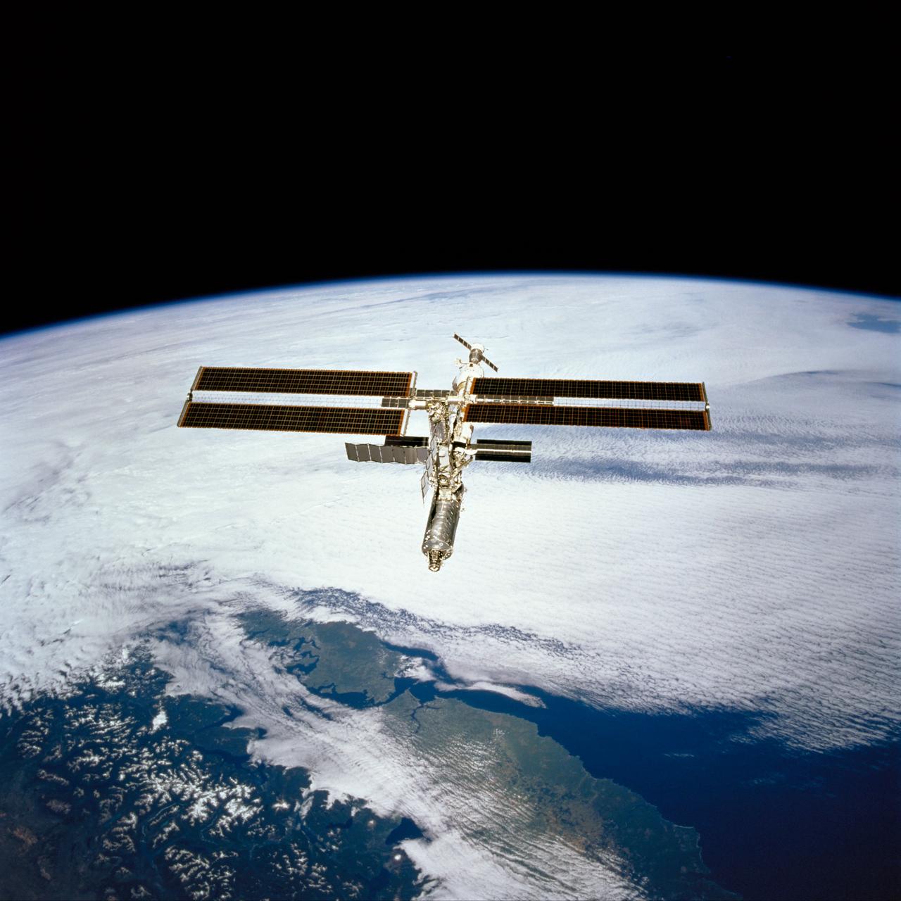 STS098-713a-016 (16 February 2001) --- The International Space Station is backdropped over clouds, water and land in South America. South central Chile shows up at bottom of the frame. Just below the Destiny laboratory, the Chacao Channel separates the large island of Chiloe from the mainland and connects the Gulf of Coronados on the Pacific side with the Gulf of Ancud southwest of the city of Puerto Montt. The crews of the Space Shuttle Atlantis and the International Space Station parted company at 8:06 a.m. (CST), February 16, as astronaut Mark L. Polansky, pilot, flew the shuttle halfway around the station and its new Destiny laboratory before moving off.