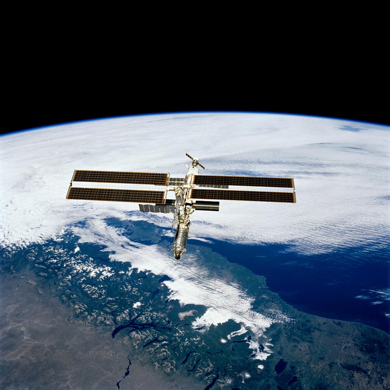 STS098-713a-019 (16 February 2001) --- The International Space Station is backdropped over clouds, water and land in South America. South central Chile shows up at bottom of the frame. Just below the Destiny laboratory, the Chacao Channel separates the large island of Chiloe from the mainland and connects the Gulf of Coronados on the Pacific side with the Gulf of Ancud southwest of the city of Puerto Montt. The crews of the Space Shuttle Atlantis and the International Space Station parted company at 8:06 a.m. (CST), February 16, as astronaut Mark L. Polansky, pilot, flew the shuttle halfway around the station and its new Destiny laboratory before moving off.