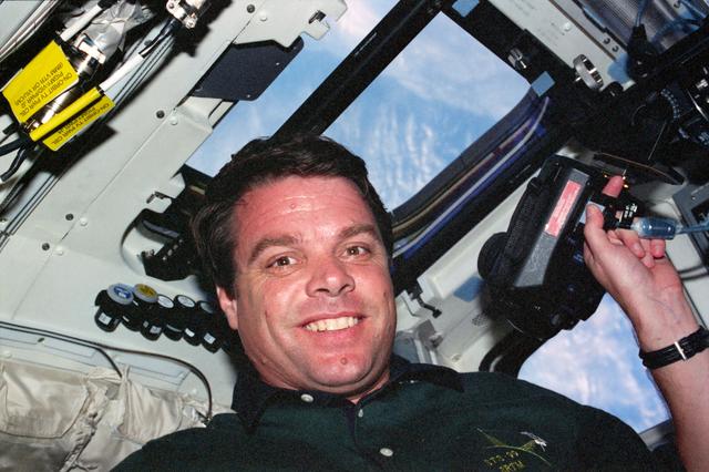 NASA image: STS-99 Commander Kregel poses with EARTHKAM camera on OV-105's flight deck