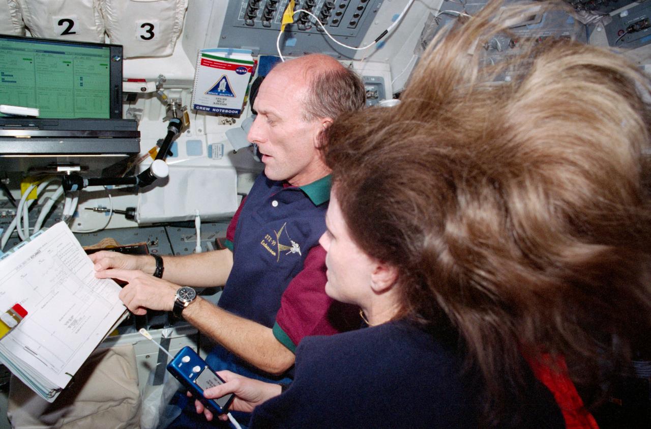 STS099-327-003 (11-22 February 2000) ---  Astronauts Gerhard P.J. Thiele and Janet L. Kavandi of the Red Team check Shuttle Radar Topography Mission (SRTM) data takes on the flight deck of the Space Shuttle Endeavour.  Both are mission specialists, with Thiele representing  the European Space Agency (ESA).