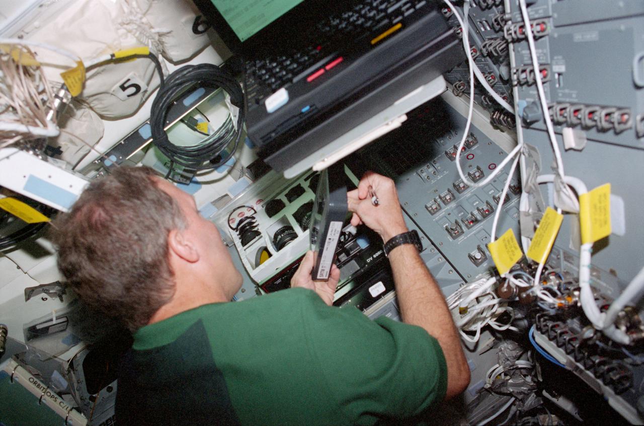 STS099-330-019 (11-22 February 2000) ---Astronaut Dominic L. Gorie, STS-99 pilot, works with camera equipment on the middeck of the Earth-orbiting Space Shuttle Endeavour.
