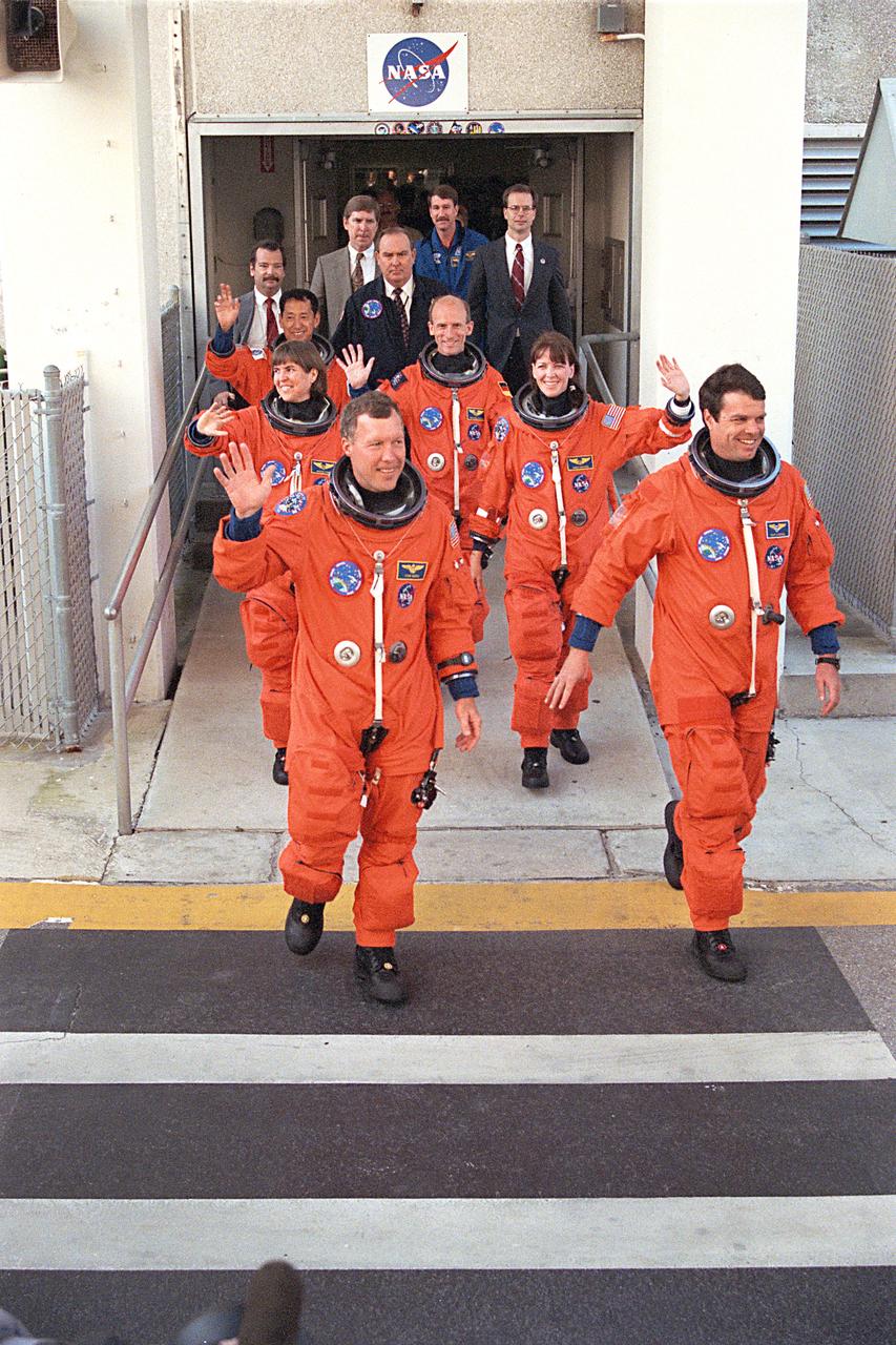 STS099-S-018 (11 February 2000) --- The STS-99 crew members wave to onlookers as they depart from the Operations and Checkout Building en route to Launch Pad 39A for liftoff of the Space Shuttle Endeavour.  Attired in their burnt-orange launch and entry suits, the crewmembers are led in front by Dominic L. Gorie (left), pilot; and Kevin R. Kregel, mission commander.  Behind them are the mission specialists (from the left) Janice Voss; Mamoru Mohri, with Japan's NASDA; Gerhard P. J. Thiele, representing the European Space Agency (ESA); and Janet L. Kavandi.  This flight is the 97th shuttle mission and the 14th flight of the Space Shuttle Endeavour.