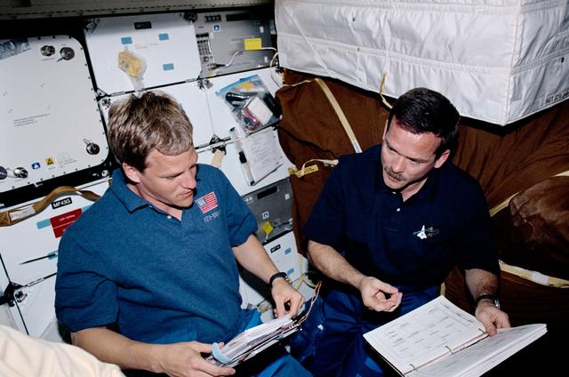 NASA image: Parazynski and Hadfield look over EVA checklists on Endeavour's middeck during STS-100