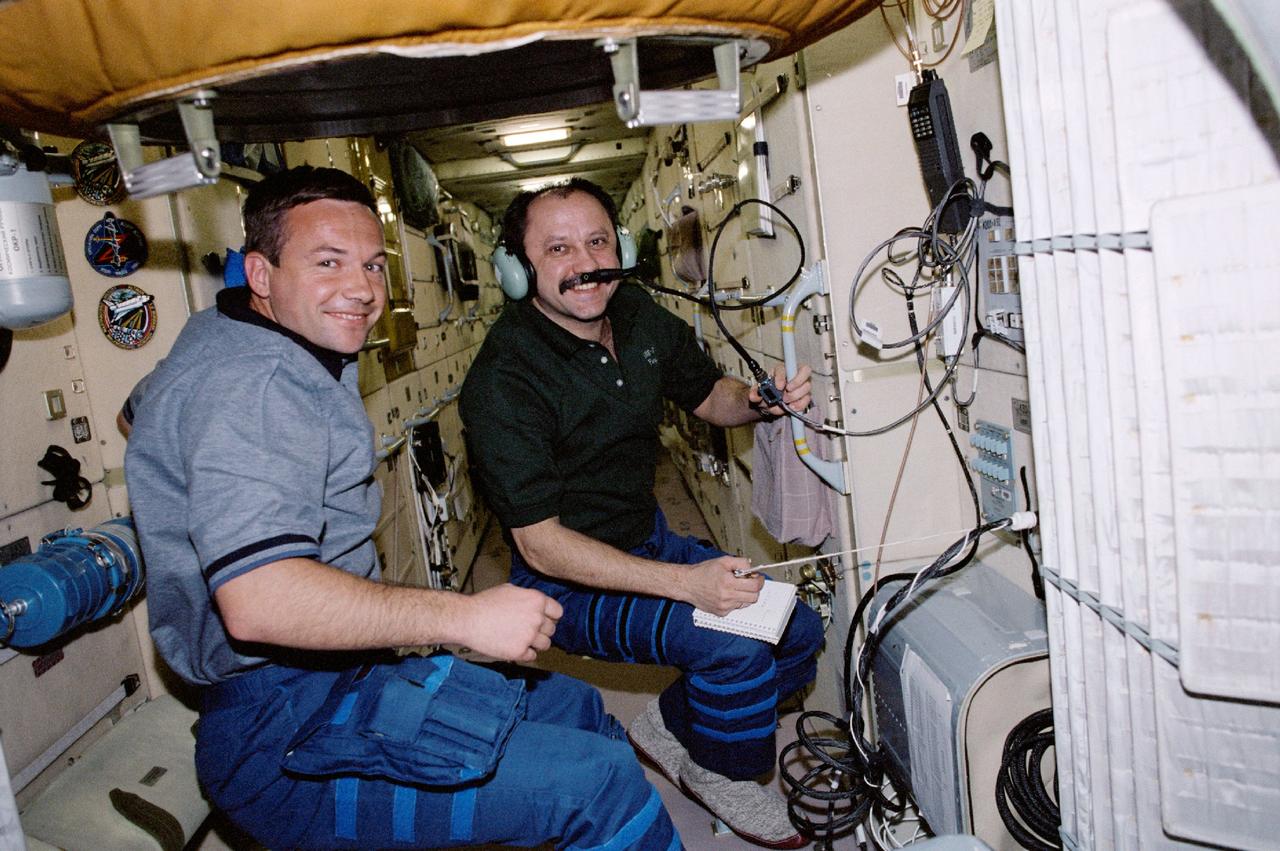 STS100-343-020 (19 April-1 May 2001) --- Cosmonaut Yuri V. Lonchakov (left), STS-100 mission specialist, observes as Yury V. Usachev, Expedition Two commander, talks to amateur radio operators on the ground from a special work station on the functional cargo block (FGB) or Zarya module of the International Space Station (ISS).  The two represent Rosaviakosmos.