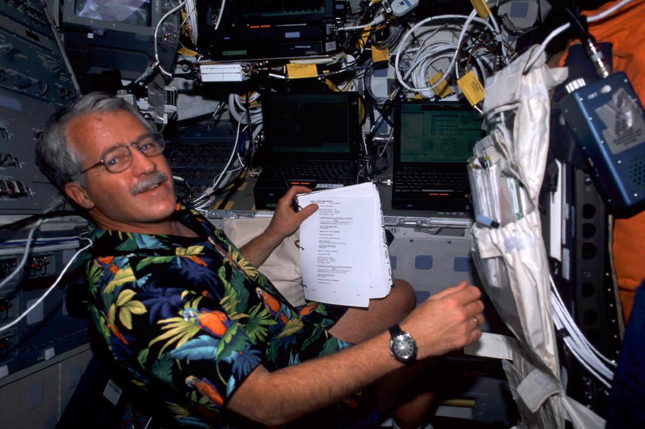 STS100-387-022 (19 April-1 May 2001) --- Astronaut John L. Phillips, STS-100 mission specialist, looks over a checklist on the flight deck of the Space Shuttle Endeavour. The alumnus of the 1996 class of astronaut candidates is making his first space flight.