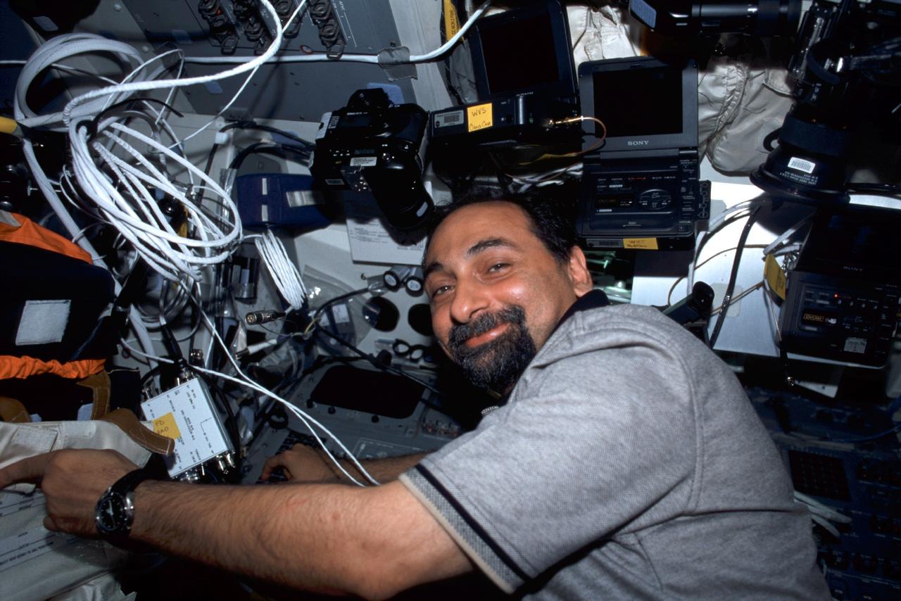 STS100-387-029 (19 April-1 May 2001) --- Astronaut Umberto Guidoni appears to be enjoying his work on the flight deck of the Space Shuttle Endeavour. The STS-100 mission specialist represents the European Space Agency (ESA) and is marking his second space shuttle mission experience.